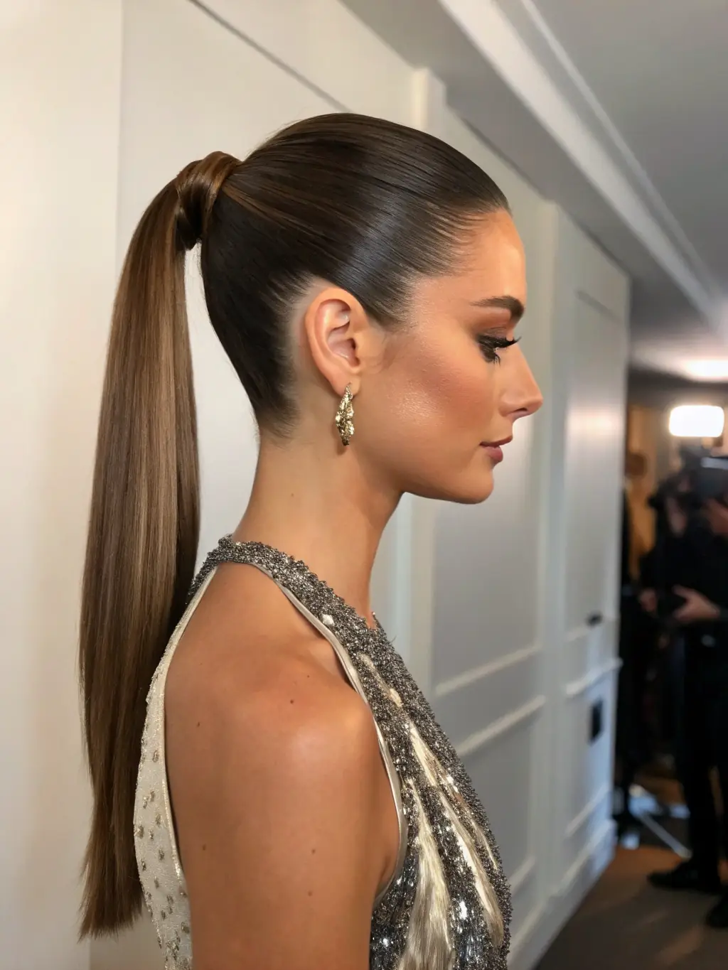 A woman with a sleek and polished hairstyle, styled by Georgia Mitchell for a gala event, complementing her elegant outfit.